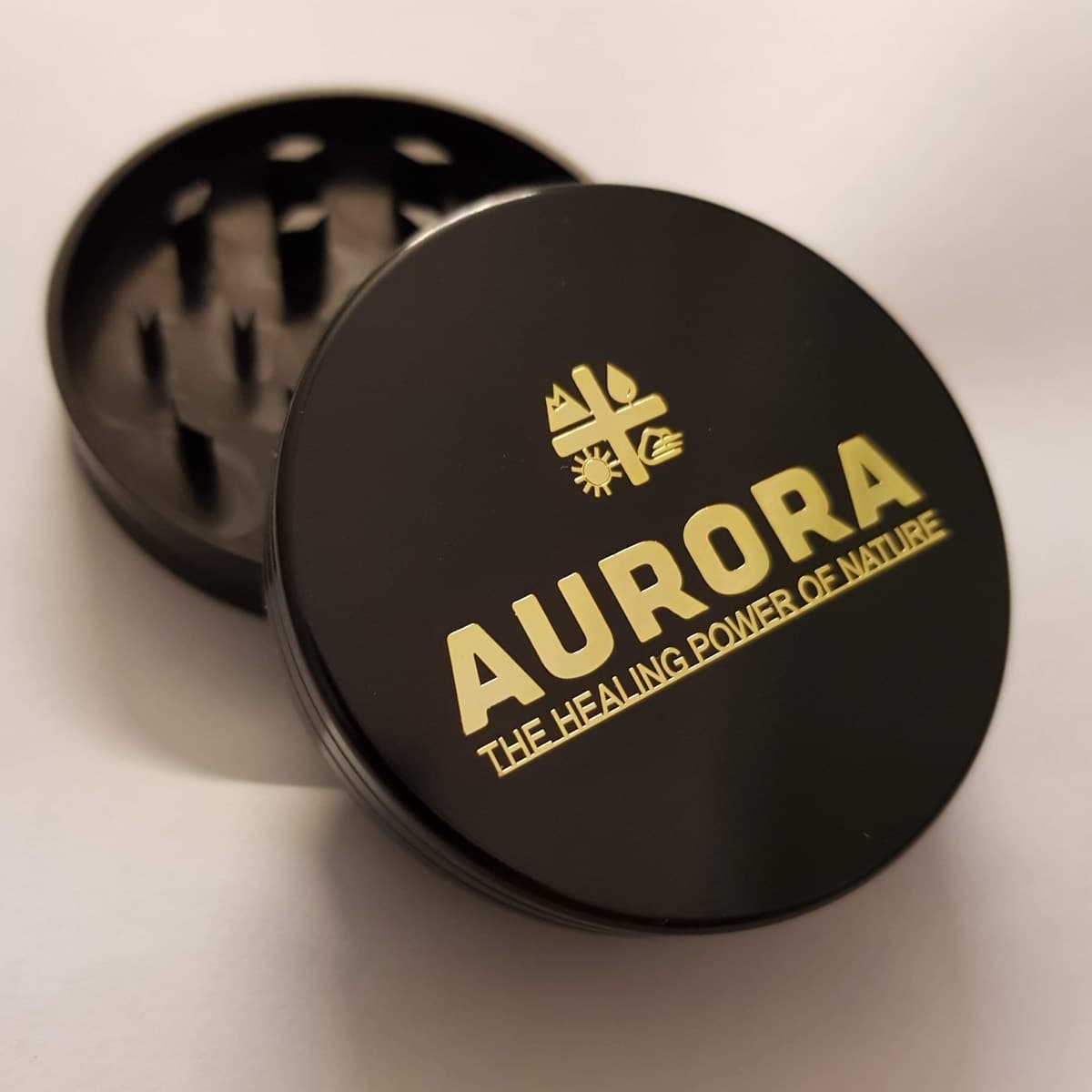 Black grinder with the Aurora logo and tagline 3D engraved in gold