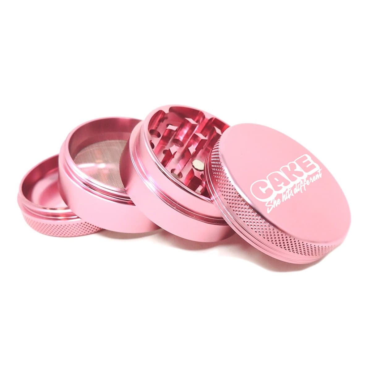 Pink anodized 4-part grinder shown in pieces, lid printed with the Cake logo