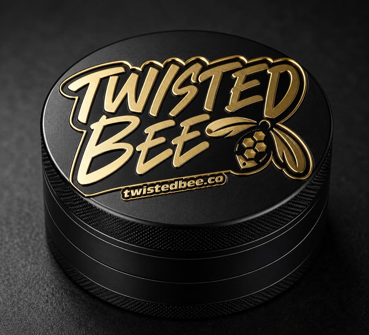 Black 2-part grinder with a gold 3D engraved Twisted Bee script logo and bee mark